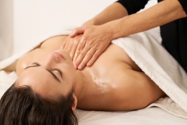 A,Woman,Massaging,The,Chest,Of,Another,Woman,Lying,On